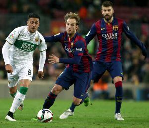 El centrocampista croata del FC Barcelona Ivan Rakitic persigue a Cristian Herrera, del Elche.
