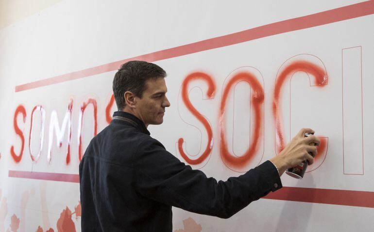 El exsecretario general del PSOE Pedro Sánchez rellena con spray una pintada en Dos Hermanas (Sevilla).