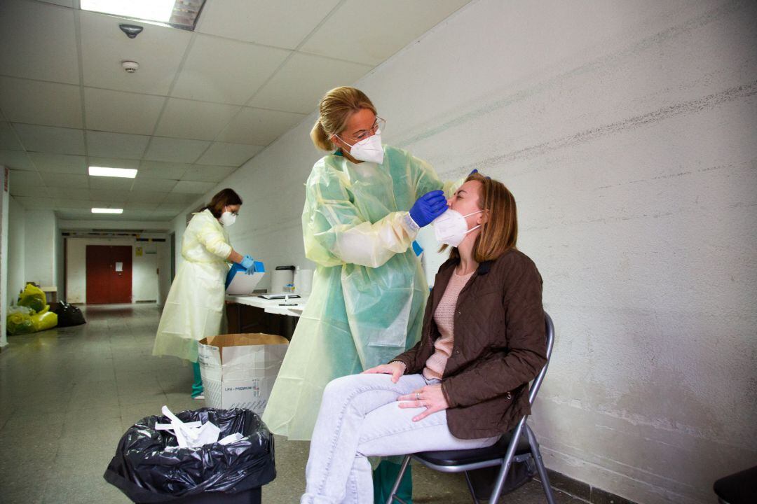 Archivo - Una sanitaria realiza un test de antígenos o una PCR a una mujer.