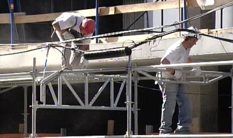 Dos operarios de la construcción trabajando en una obra