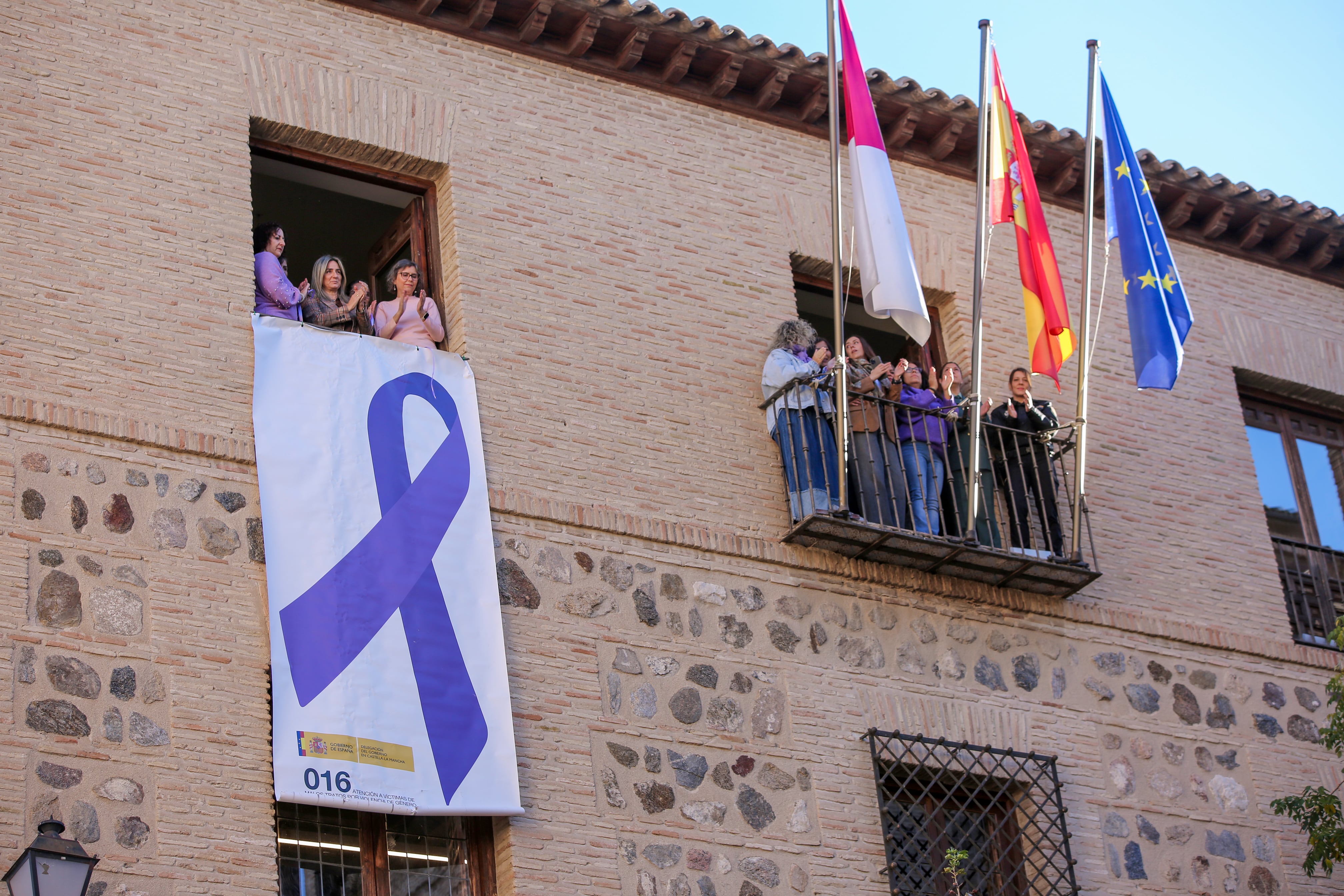 Milagros Tolón despliega en la Delegación del Gobierno, en Toledo, el lazo morado contra la violencia machista.