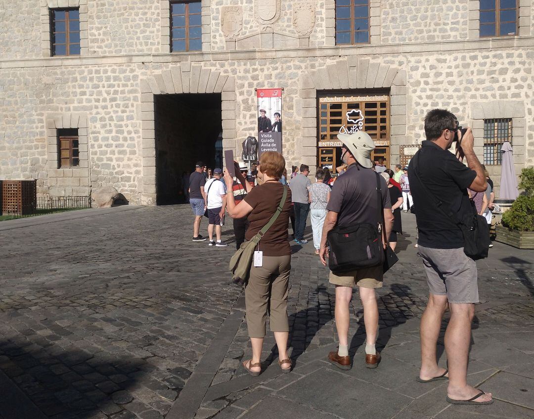 Turistas tomando fotos junto a la Oficina de Información Turística en la Puerta de la Catedral