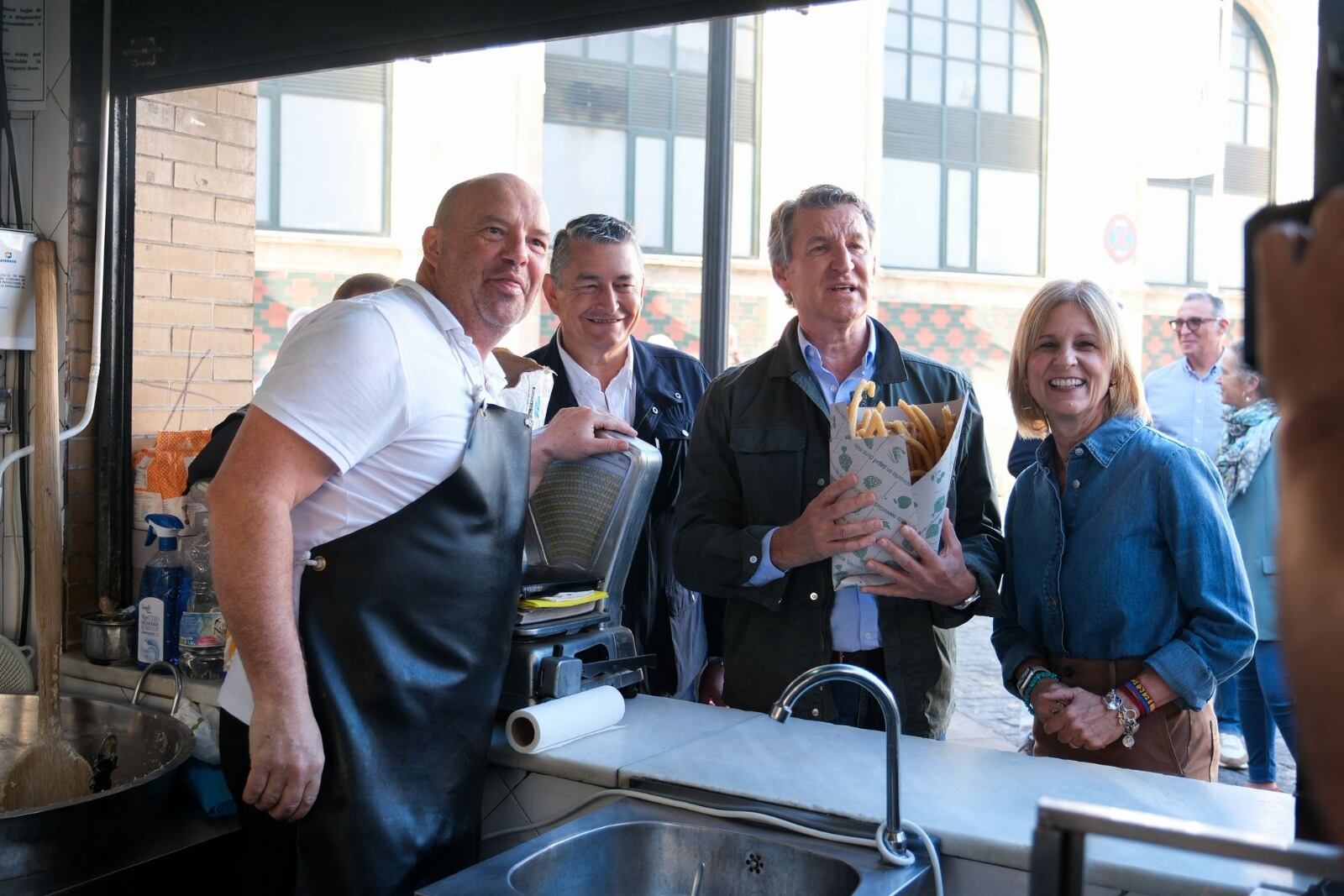 Sanz, Feijóo y Pelayo en el puesto de churros junto a la plaza de Abastos de Jerez este domingo