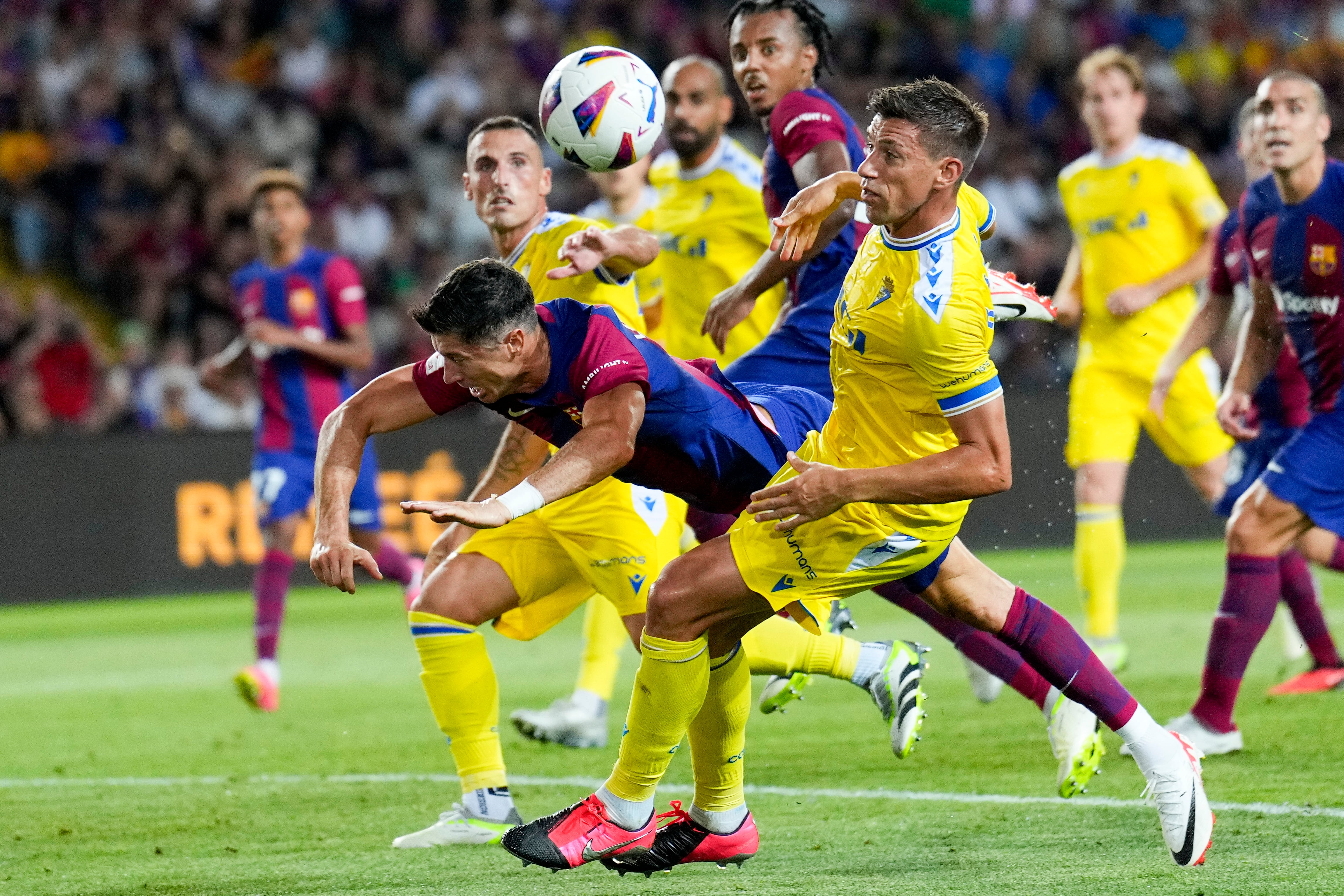 BARCELONA 20/08/2023.- El delantero polaco del FC Barcelona Robert Lewandowski (i) cae junto a Rubén Alcaraz, del Cádiz CF, durante el partido que enfrenta este domingo al FC Barcelona y al Cádiz CF en la segunda jornada de LaLiga en el Estadio Olímpico de Barcelona. EFE/ Alejandro García