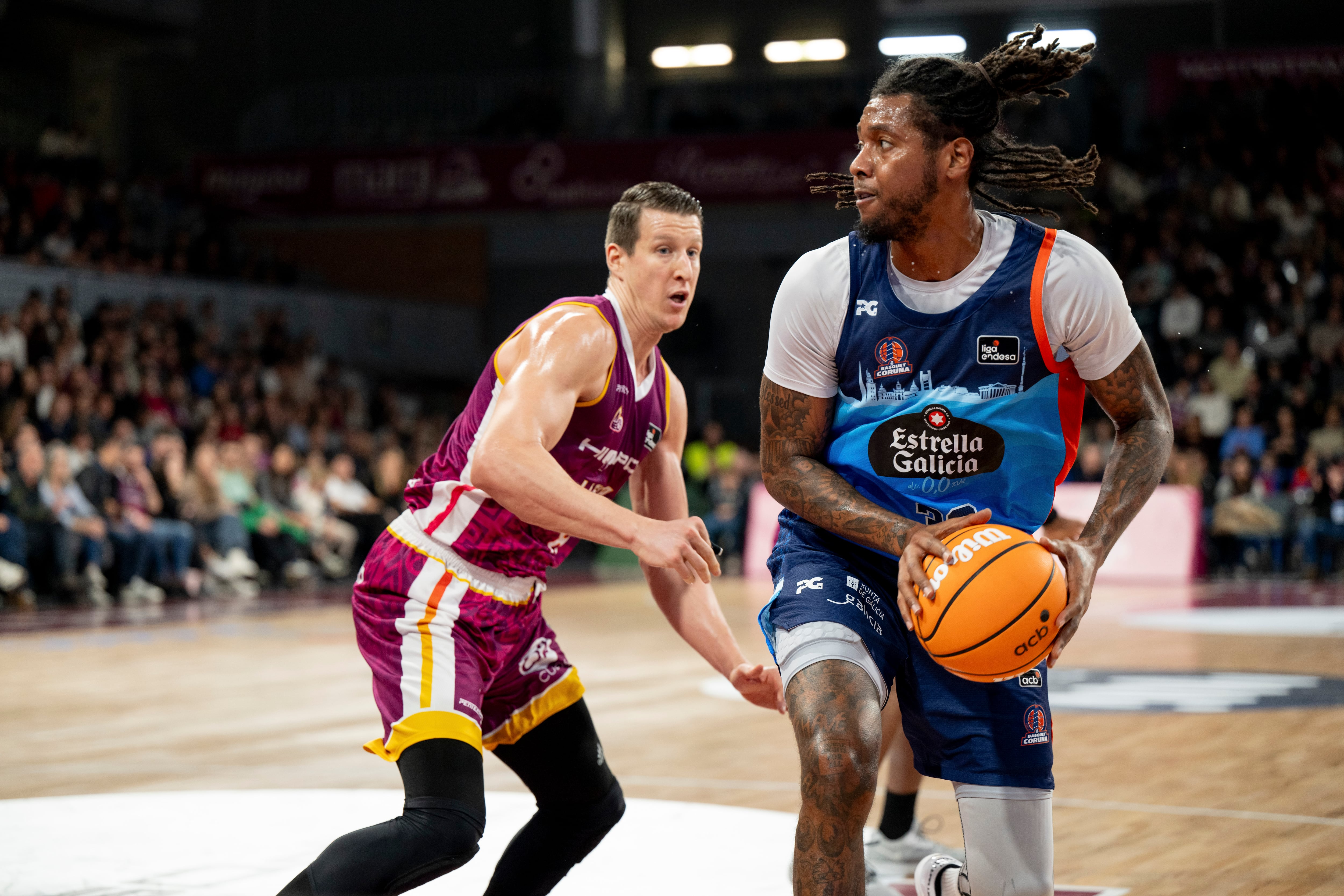 LLEIDA, 01/12/2024.- El ala pívot estadoundiense del Leyma Coruña Trey Thompkins (d) lanza ante el alero croata del Hiopos Lleida Luka Bozic en el partido de Liga Endesa que se disputa este domingo en el pabellón Barris Nord. EFE/ Alex López
