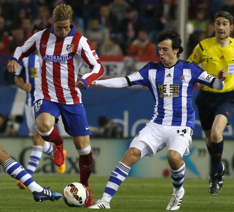 GRA371. MADRID, 07/04/2015.- El delantero del Atlético de Madrid Fernando Torres (c) con el balón ante los jugadores de la Real Sociedad Markel Bergara (i) y Rubén Pardo (d), durante el partido de trigésima jornada de liga de Primera División disputado esta tarde en el estadio Vicente Calderón. EFE/Kiko Huesca