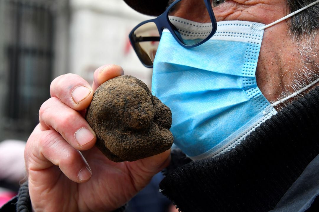 Un hombre oliendo una trufa a través de la mascarilla