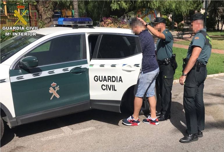 El detenido custodiado por los agentes en el barrio malagueño de Churriana