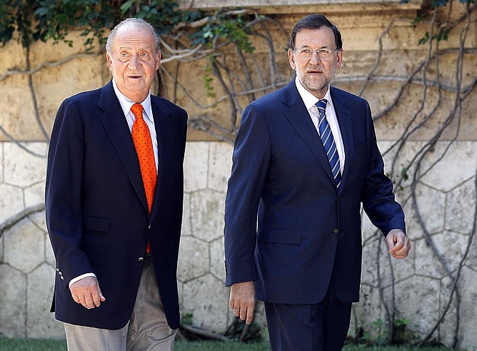 El rey Juan Carlos conversa con el presidente del Gobierno Mariano Rajoy antes de la reunión en el palacio de Marivent