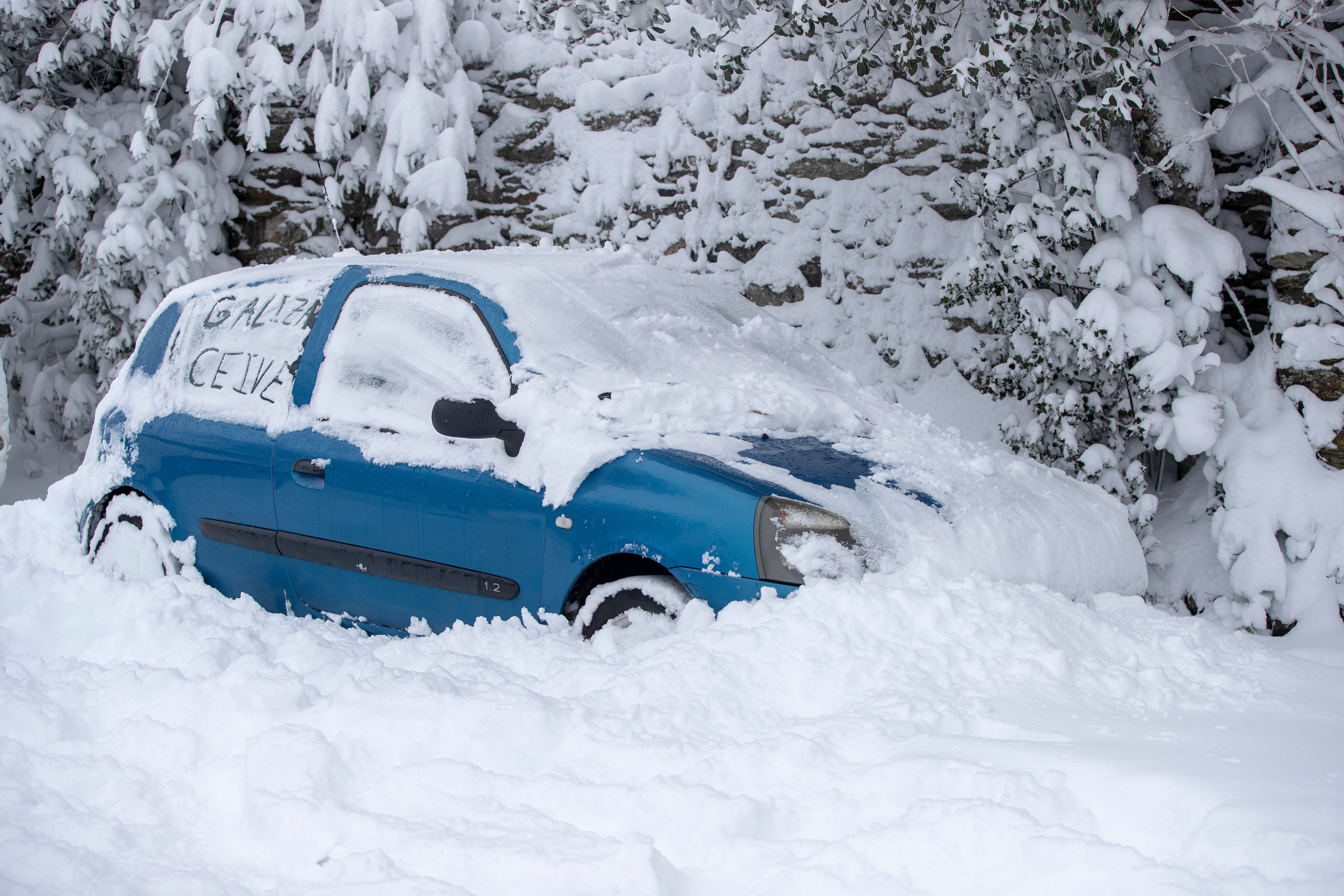 La nieve sepulta a varios vehículos que permanecen estacionados, este miércoles en Pedrafita do Cebreiro, Lugo.