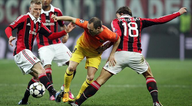 El centrocampista del FC Barcelona, Andrés Iniesta, pelea por el control del balón con los jugadores del AC Milan