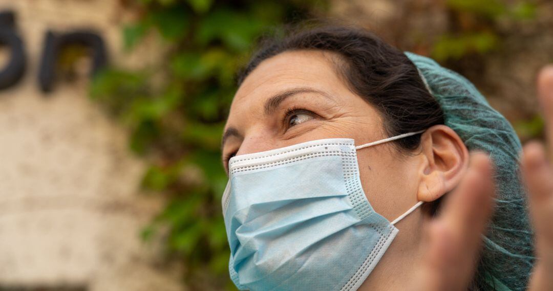 Sanitaria a las puertas de un centro hospitalario, ataviada con una mascarilla quirúrgica