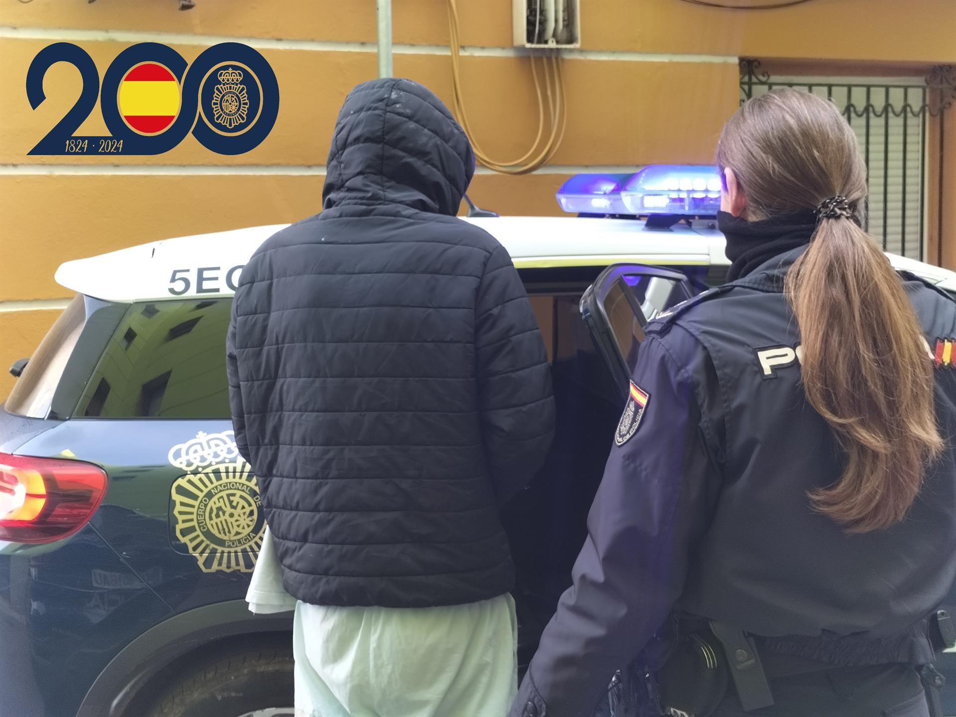 Imagen de uno de los detenidos, custodiados por agentes de la Policía Nacional