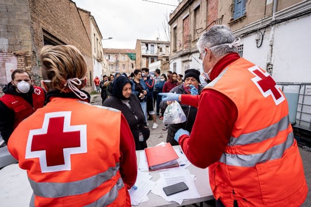 Voluntarios de Cruz Roja reparten comida y material higiénico a personas sin recursos en València durante la pandemia del coronavirus