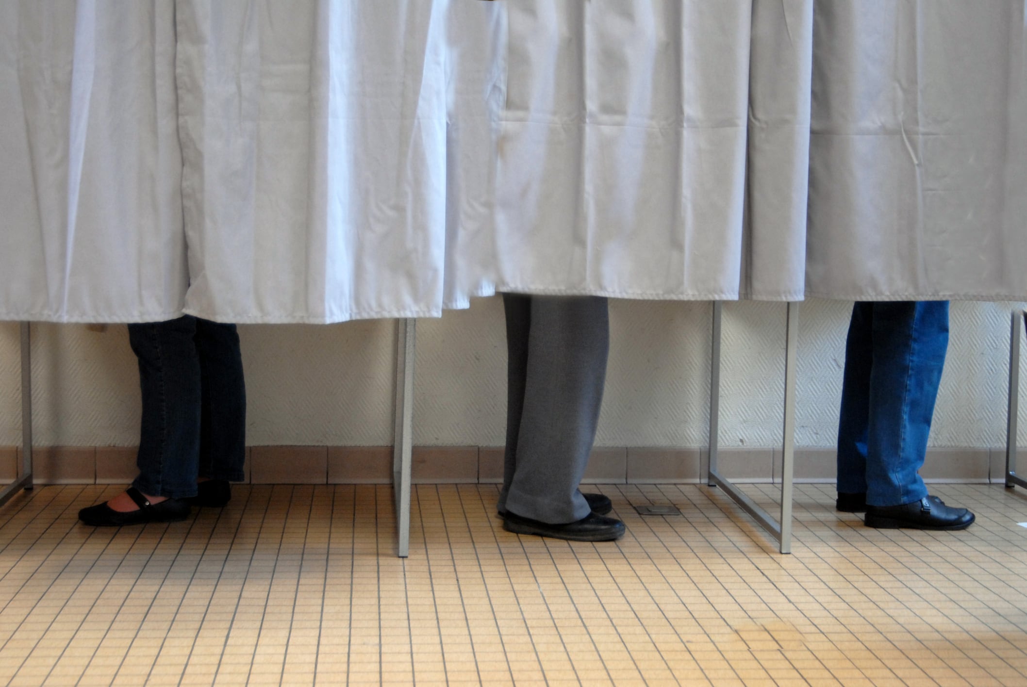 Un grupo de personas, preparando sus papeletas, en un colegio electoral.