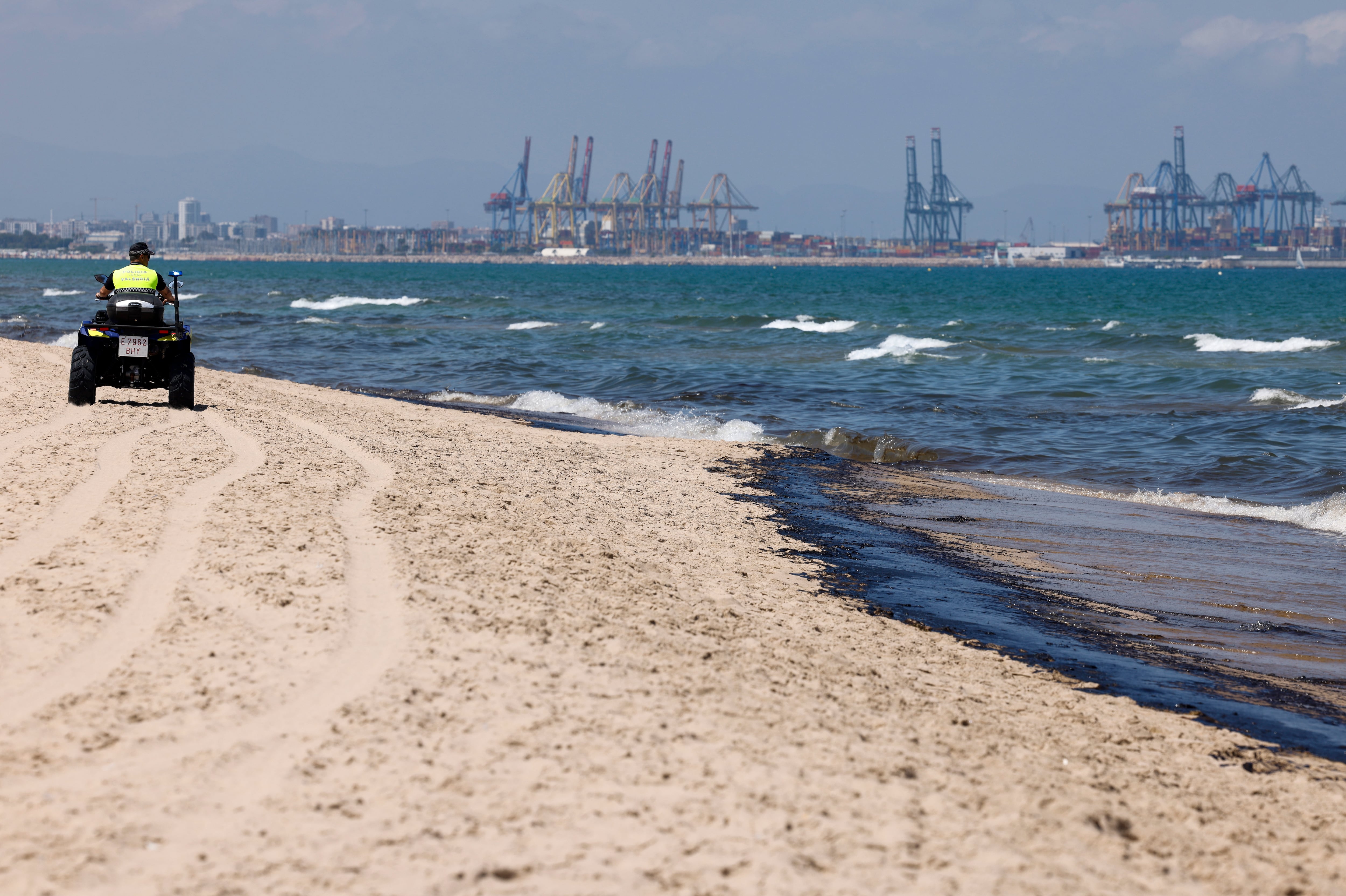 Un agente de la Policía Local recorre la playa afectada por el vertido de combustible, que según las primeras estimaciones mide entre 1,5 y dos kilómetros, y que ha obligado a prohibir el baño en las playas de l&#039;Arbre del Gos y El Saler, en València, donde se ha puesto la bandera roja, según fuentes municipales y de la Generalitat.