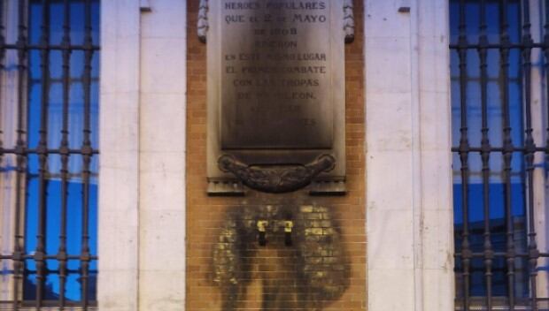 Placa en la fachada de la Casa Real de Correos, carbonizada.