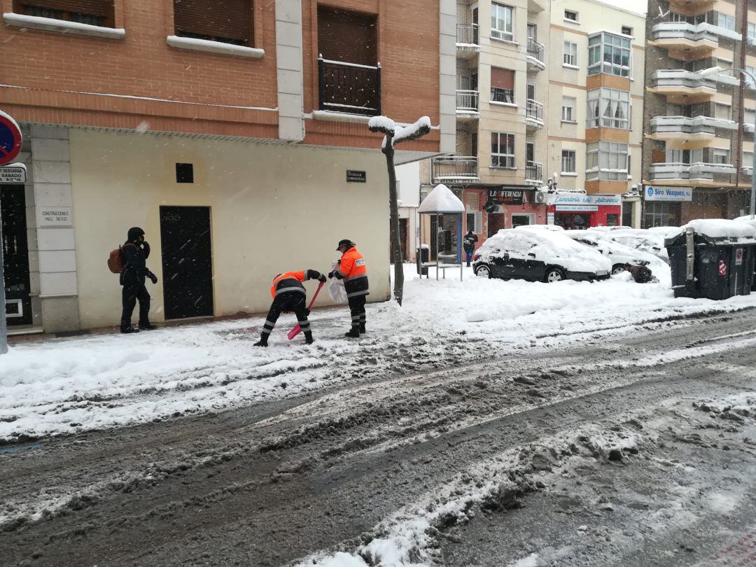 Voluntarias de Protección Civil colaboran en despejar la acera de la calle Carrequemada de nieve