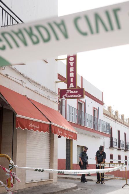 La guardia Civil precinta las inmediaciones de la joyería de la calle Pablo Neruda de Carmona (Sevilla), donde su propietario fue encontrado muerto y amordazado en la tarde de ayer en circunstancias que se están investigando