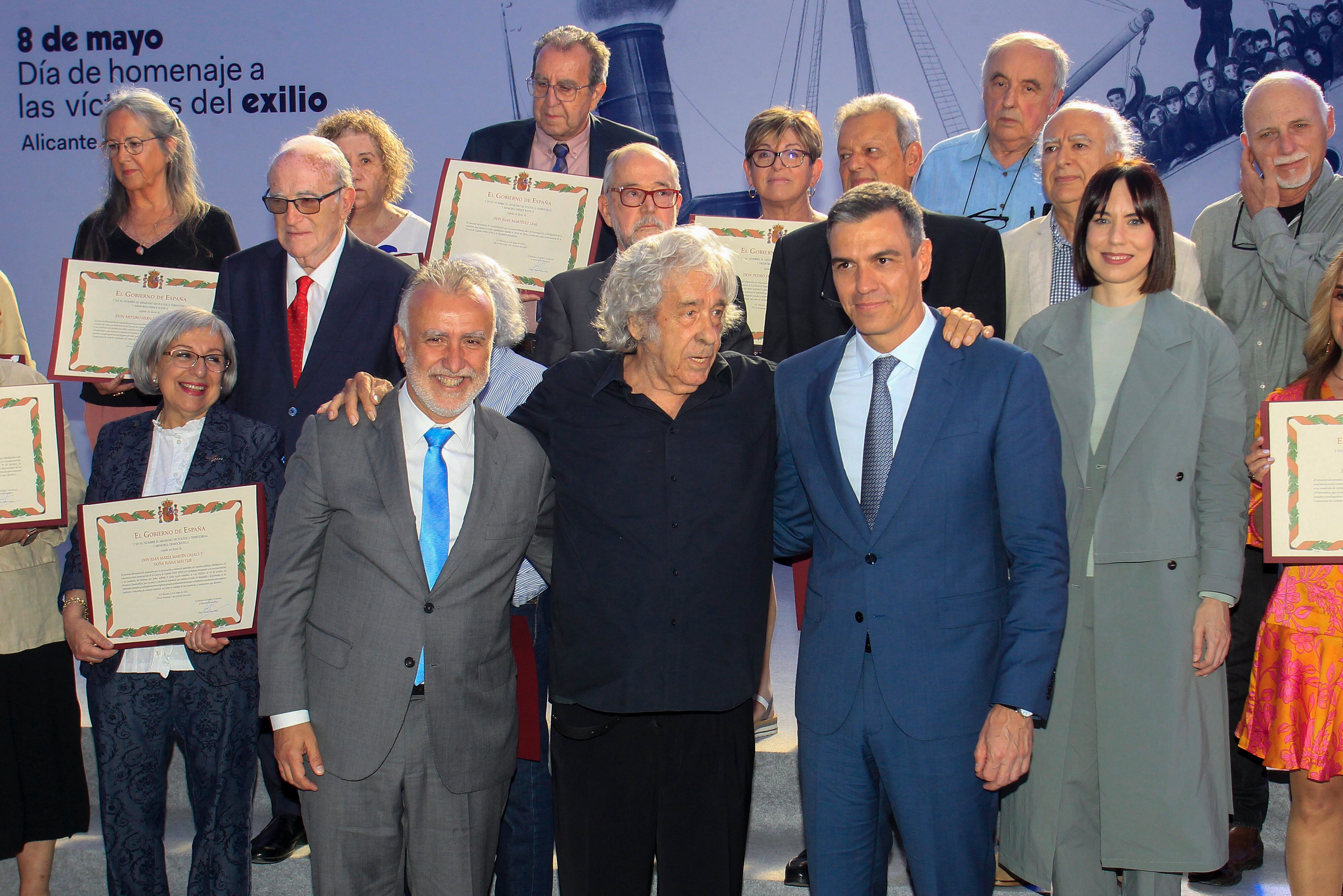 El presidente del gobierno, Pedro Sánchez (2º d), el ministro de Política Territorial y Memoria Democrática, Ángel Víctor Torres (2º i), y la ministra de Ciencia, Innovación y Universidades, Diana Morant (d), posan con el cantautor, Paco Ibañez (c), y los familiares de los homenajeados en el acto de celebración este miércoles del &#039;Día de recuerdo y homenaje a los hombres y mujeres que sufrieron el exilio como consecuencia de la Guerra y la Dictadura&quot;