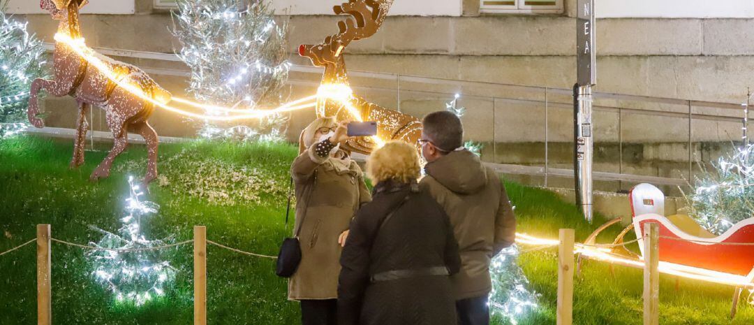 Una mujer se fotografía ante el decorado navideño