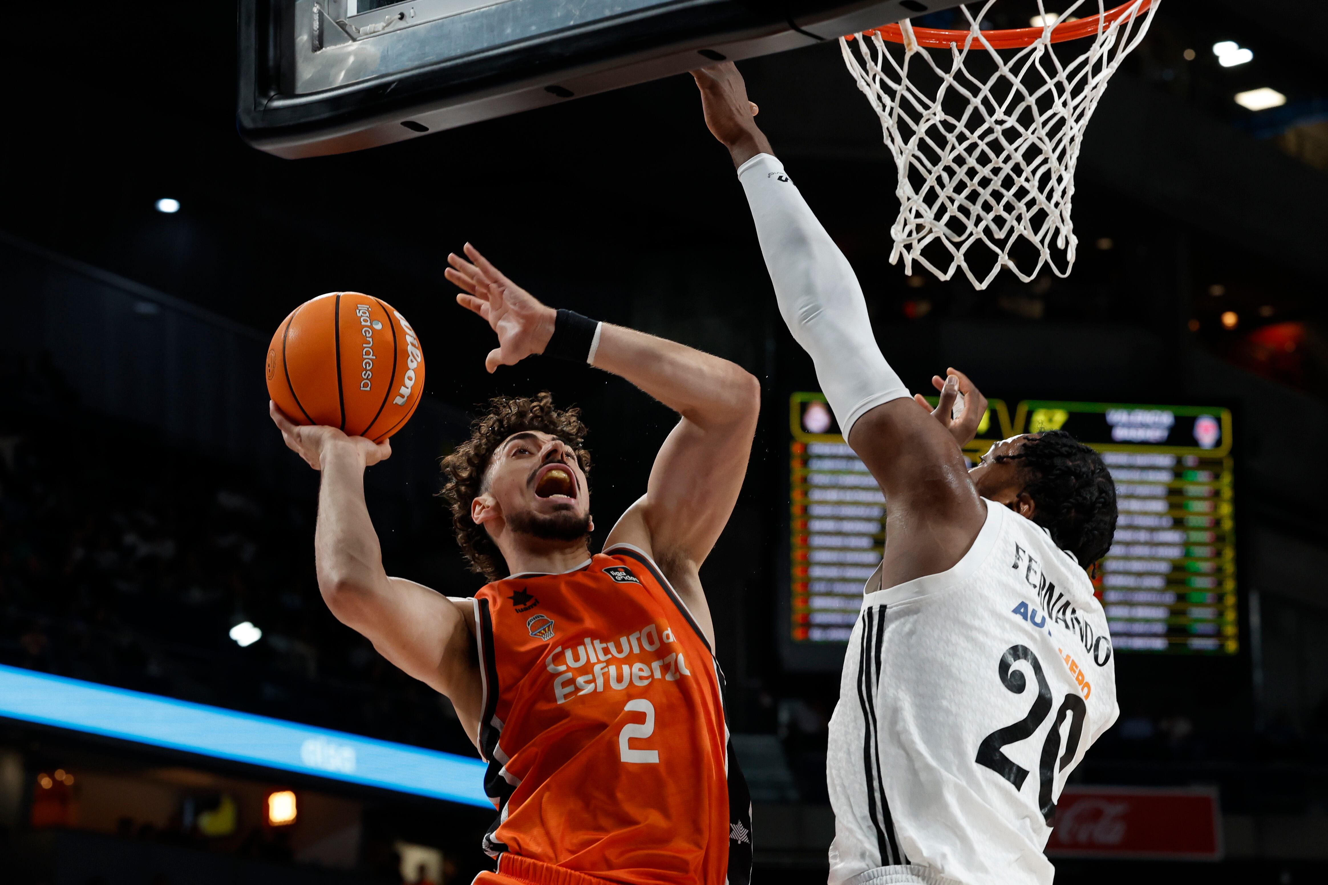 MADRID, 04/05/2025.- El base del Valencia Josep Puerto (i) entra a canasta ante el alero angolés del Real Madrid Bruno Fernando durante un encuentro correspondiente a la jornada 30 de Liga Endesa disputado este domingo entre el Real Madrid y el Valencia Basket en el Movistar Arena de Madrid. EFE/ Juan Carlos Hidalgo