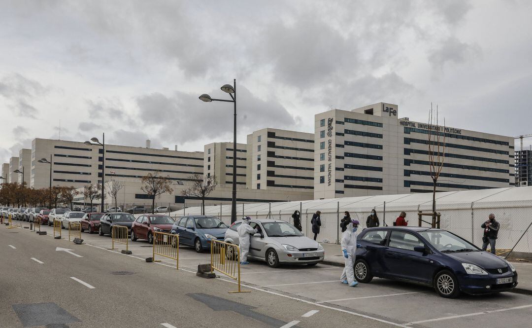 Varias personas esperan en su coche a realizarse una prueba PCR a las puertas del Hospital de Campaña próximo al de La Fe, en Valencia