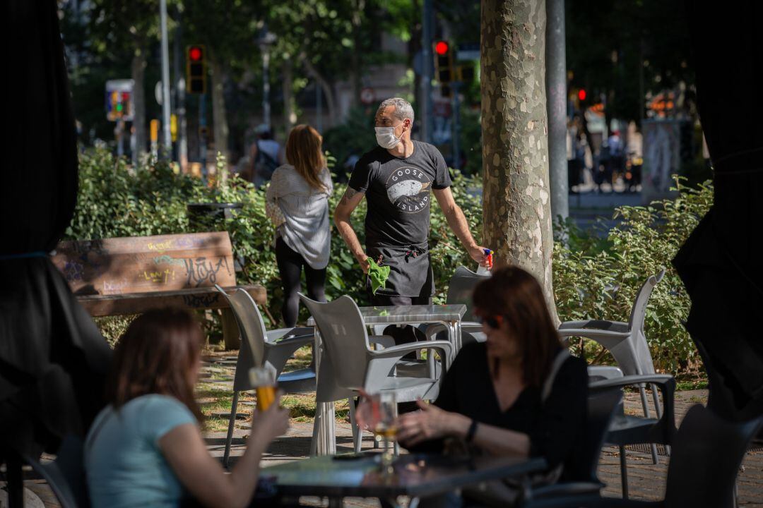 Varias personas disfrutan en la terraza de un bar en Barcelona