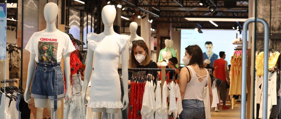 Personas con mascarilla en el interior de una tienda de ropa