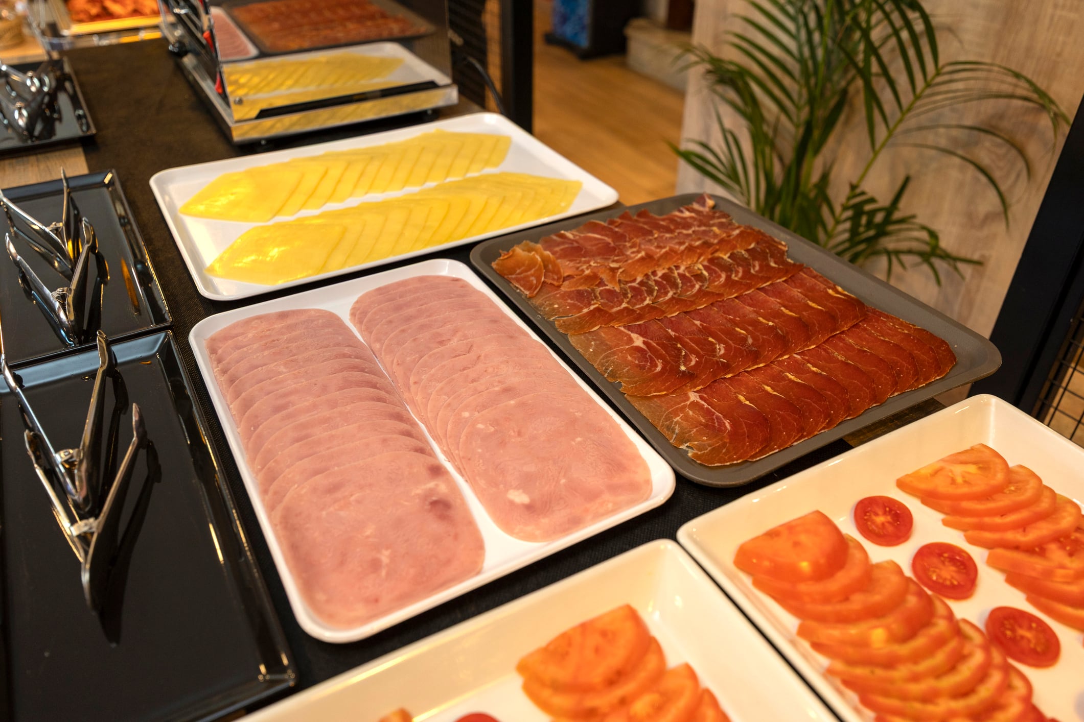 Queso, jamón y tomate en un &#039;buffet&#039; de desayuno de hotel.
