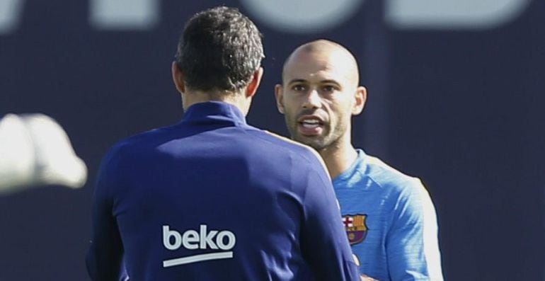 El entrenador del FC Barcelona, Luis Enrique Martínez (de espaldas), conversa con el defensa Javier Mascherano, durante una sesión de entrenamiento