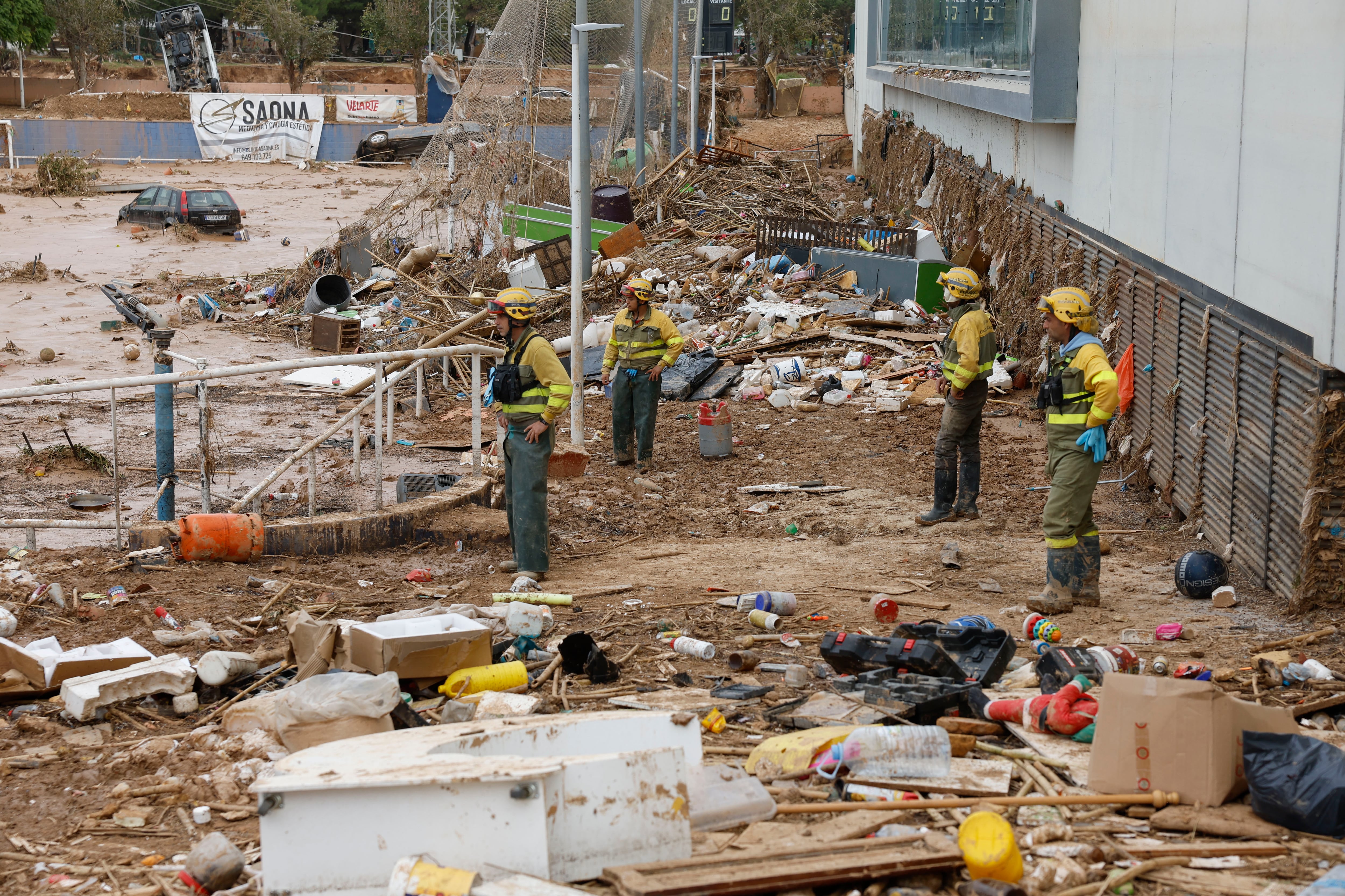 Varios bomberos trabajan en la limpieza de los accesos a la piscina municipal este martes, en Paiporta. de miles de personas y condicionado la economía, el transporte y la educación de la provincia; dos semanas después prosigue el goteo de mejoras en infraestructuras y servicios básicos y, en paralelo, la polémica política por la gestión de la catástrofe. EFE/Jorge Zapata