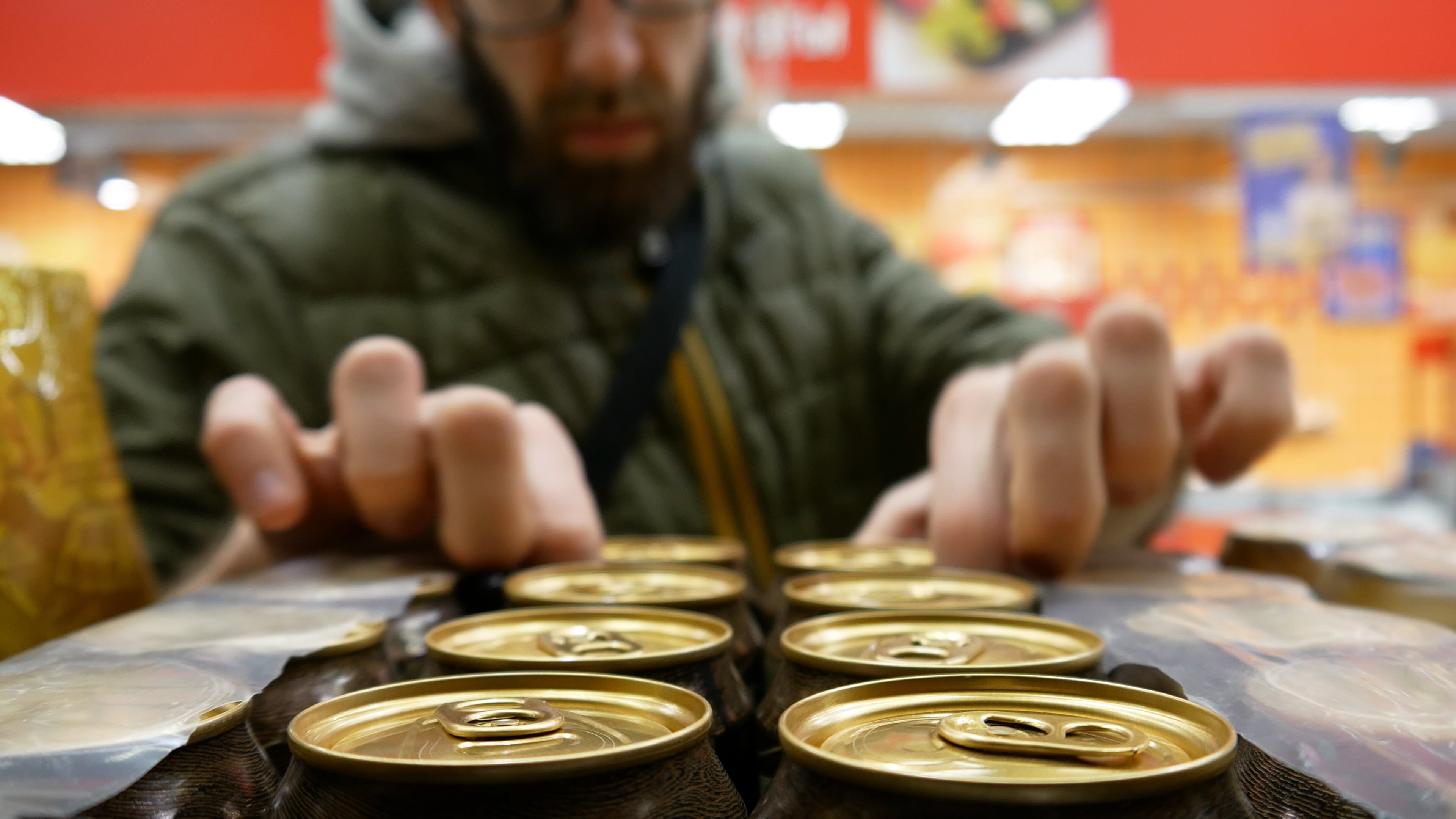 Comprando latas de cerveza en el supermercado.