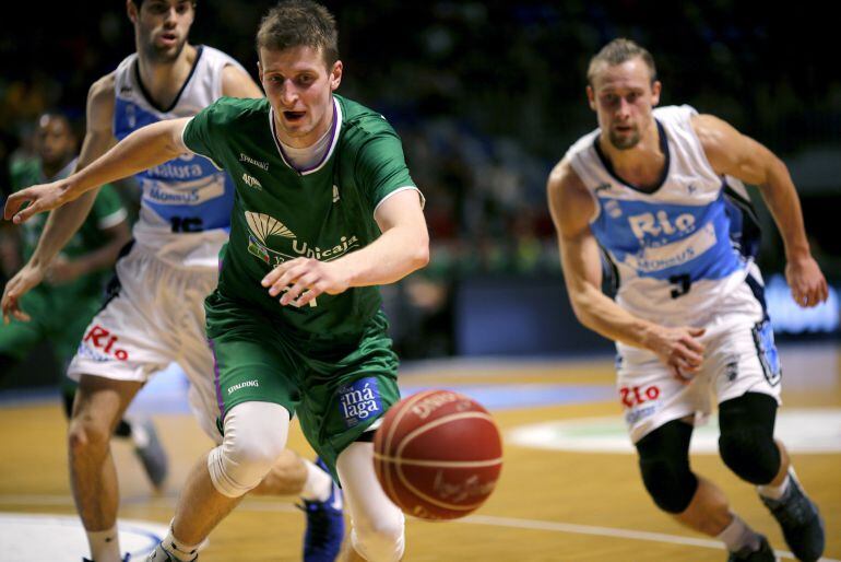 El alero polaco del Unicaja Adam Waczynski, corre tras el balón ante Santi Yusta y Dulkys