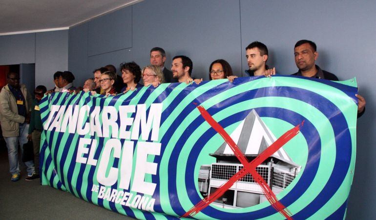 Pancarta de Tancarem el CIE de Barcelona, subjectada pels representants dels grups municipals que donen suport a la declaració institucional i de les entitats socials promotores de la iniciativa