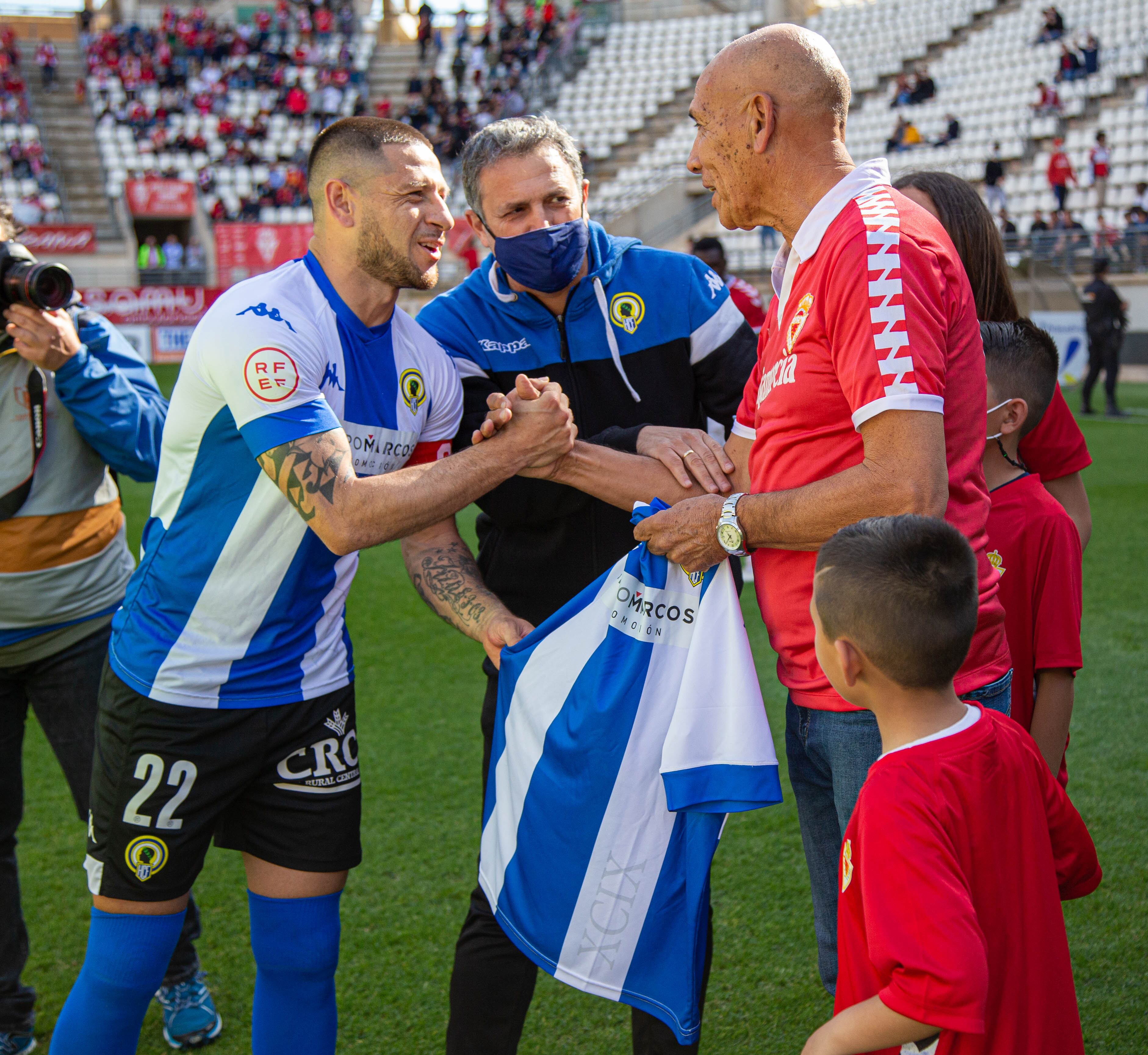Horacio Moyano, embajador del Hércules CF, recibe una camiseta de Javier 'Toro' Acuña, en La Nueva Condomina