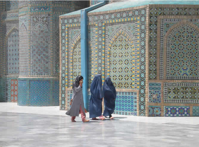 Unas mujeres pasean por la mezquita de Mazar-ISharif llevando el burka