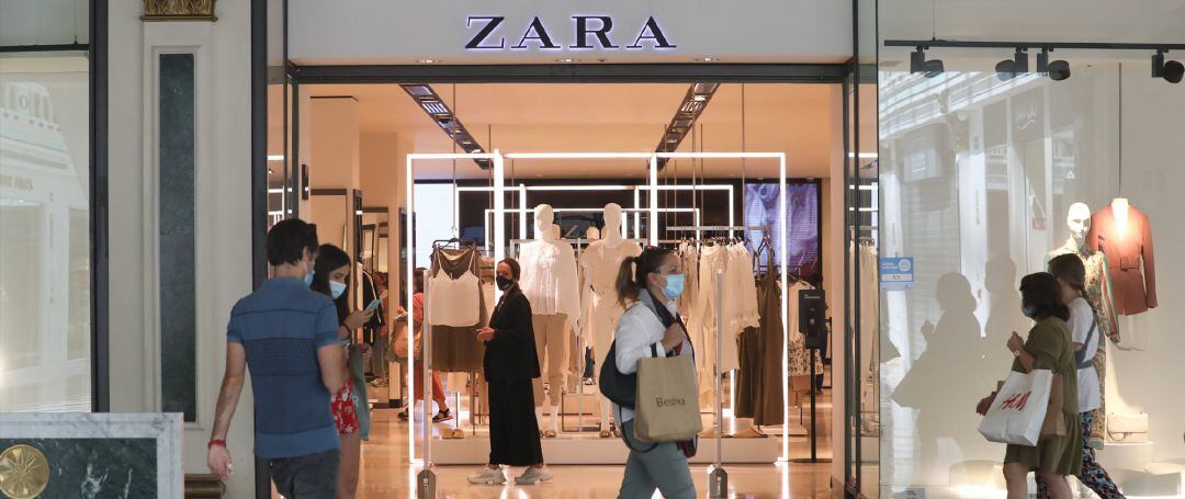 Varias personas pasan junto a una tienda Zara