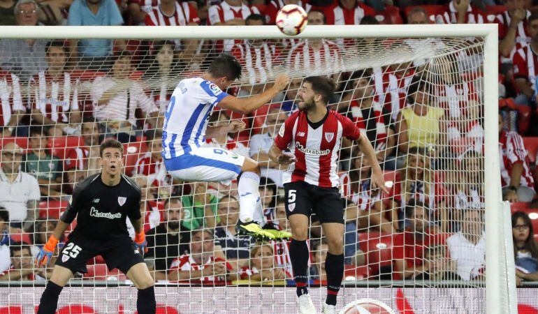 El delantero argentino del Leganés Guido Carrillo (c) remata de cabeza junto a Yeray Álvarez (d), del Athletic de Bilbao, en el partido de la primera jornada de Liga en Primera División.