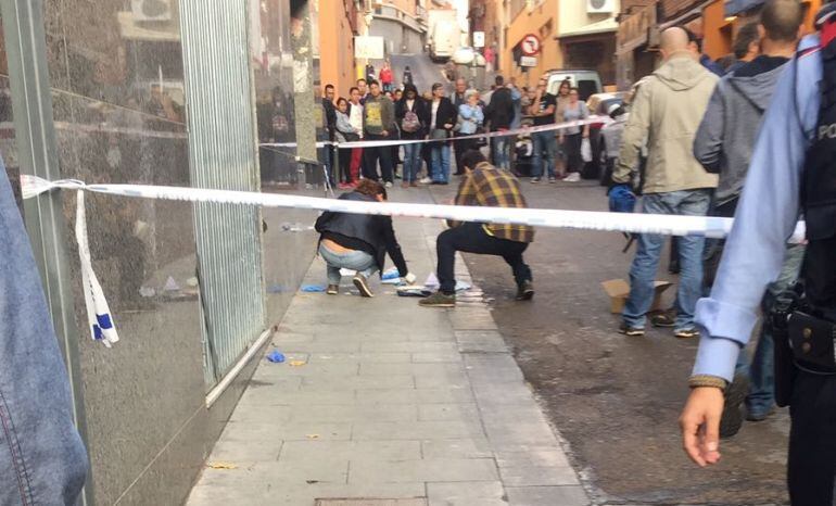 Agentes de los Mossos d'Esquadra trabajan en el lugar del apuñalamiento, en plena calle de Santa Coloma de Gramenet (Barcelona)
