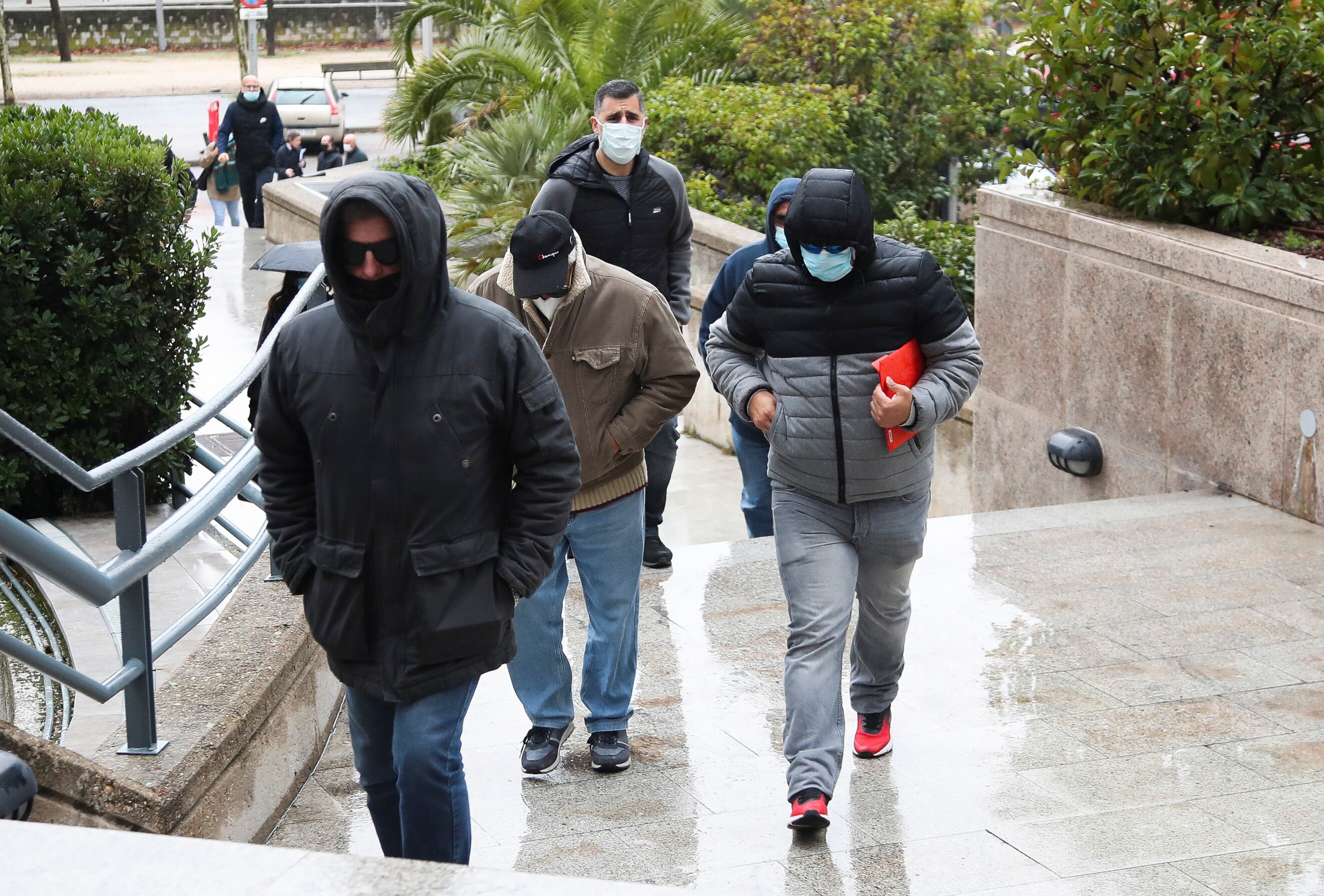 Algunos de los 23 procesados por integrar una red nacional que organizaba peleas de perros ilegales a su llegada a la sede de la Audiencia Provincial de Madrid este lunes cuando comienza el proceso