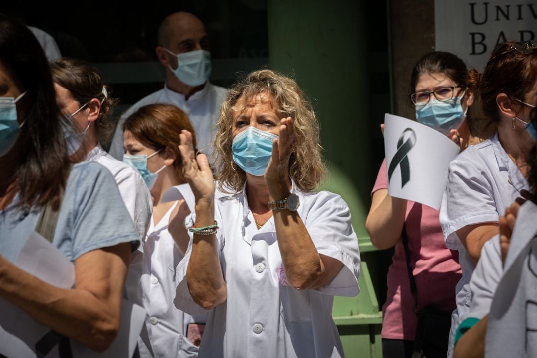 Varias trabajadoras protegidas con mascarilla se reúnen a las puertas del Hospital Clínic de Barcelona.