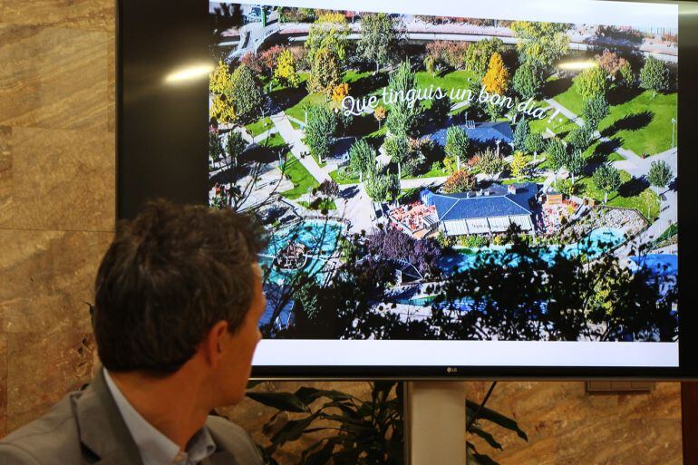 El conseller comunal, David Astiré, mostrant una de les imatges proposades als vinils que cobriran aparadors i tanques d'obres a Andorra la Vella.