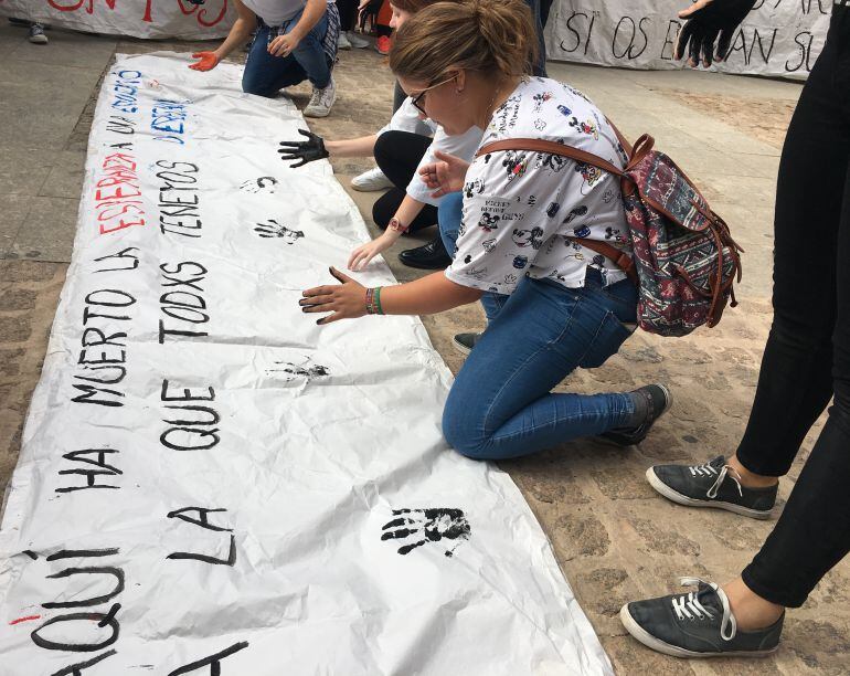 Todos los estudiantes han puesto su mano en una pancarta