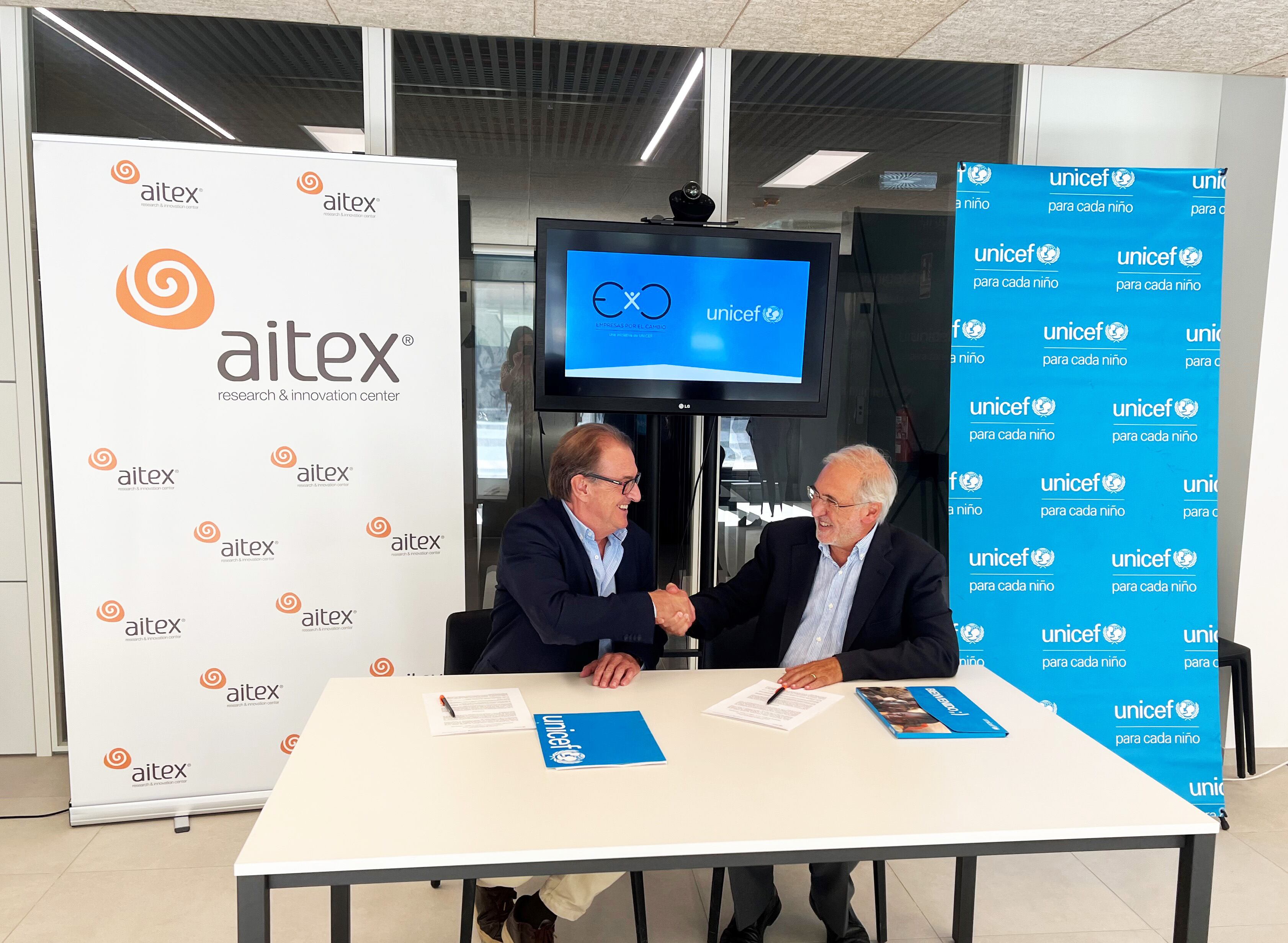 Vicente Blanes, director general de AITEX y Jorge Cardona, presidente del Comité de Unicef de la Comunidad Valenciana, firman el acuerdo en las nuevas instalaciones de AITEX