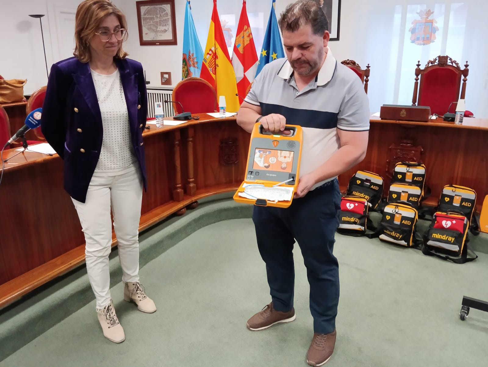 El representante de la empresa adjudicataria muestra el funcionamiento de los desfibriladores portátiles en presencia de la alcaldesa, Raquel González