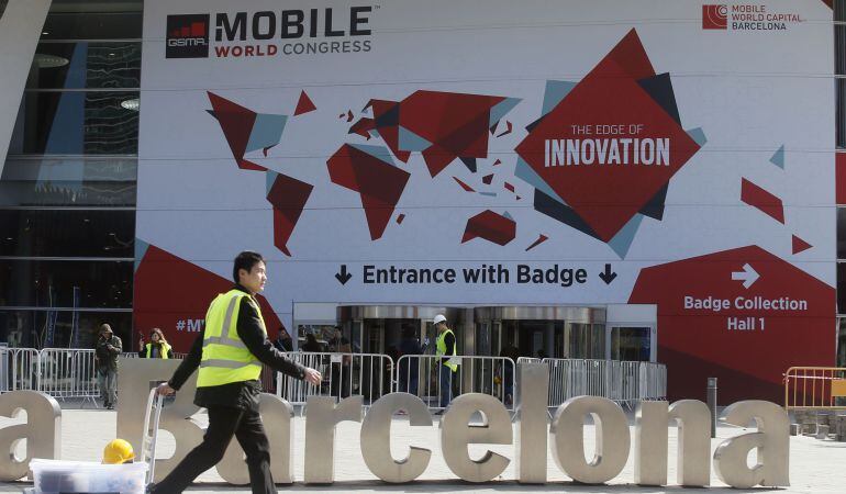 Un trabajador tira de una maleta en la entrada del Mobile World Congress de Barcelona