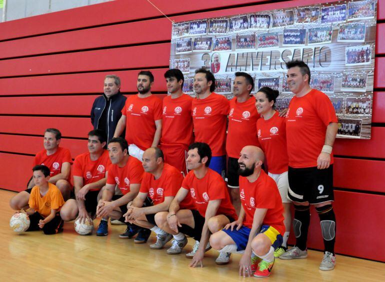 Equipo de veteranos ante el panel conmemorativo