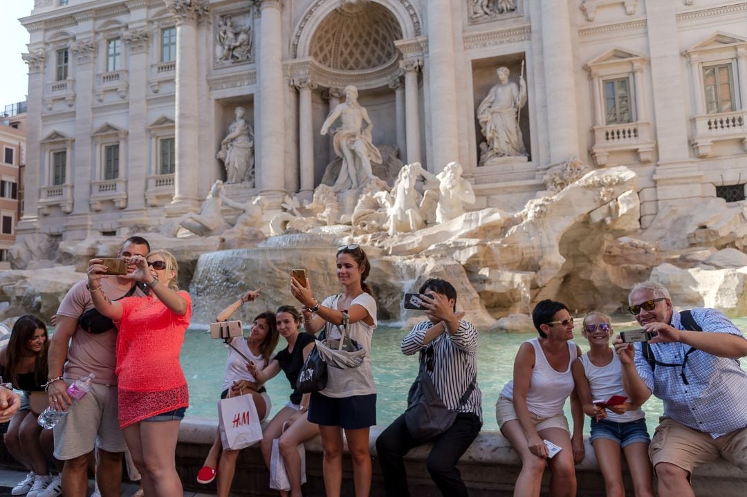 Un grupo de turistas se hace fotografías en la Fontana de Trevi