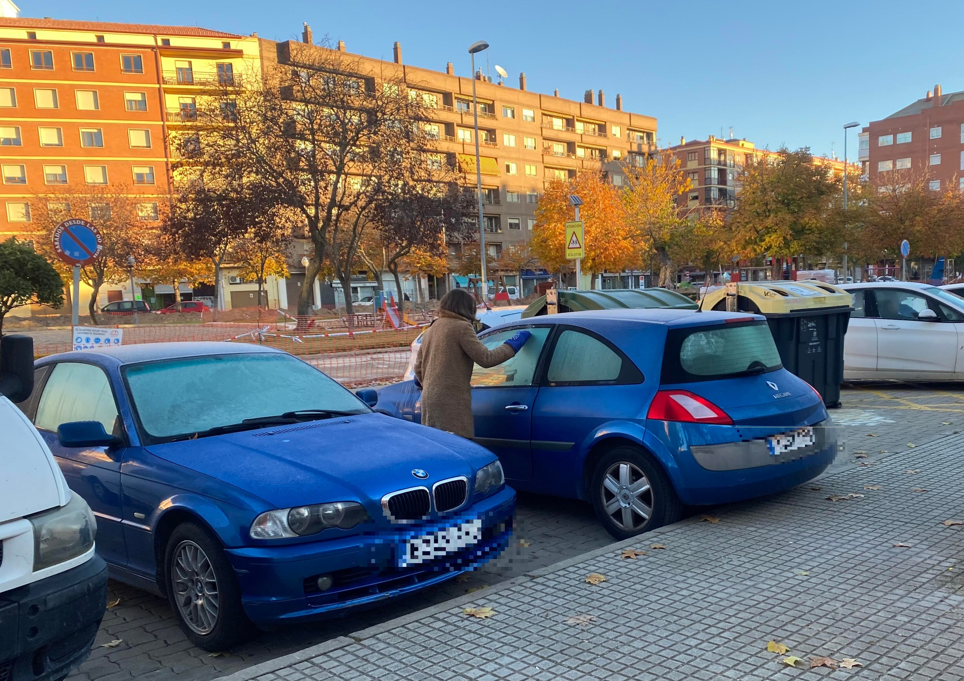 Una mujer rasca la ventanilla de su coche tras una helada en Aranda